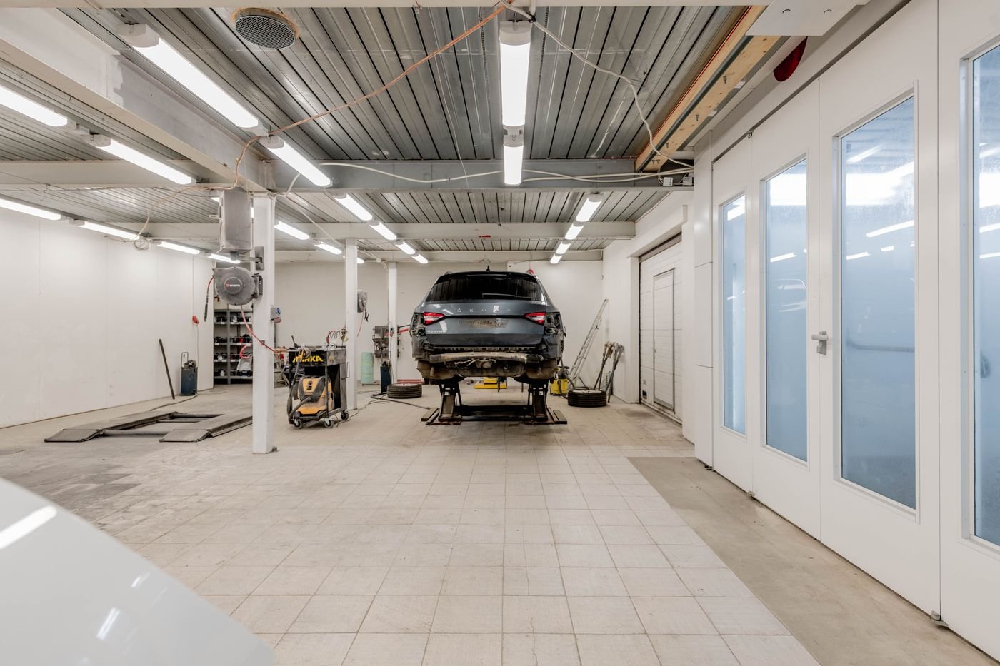 Officina con auto sul ponte e pavimento in resina